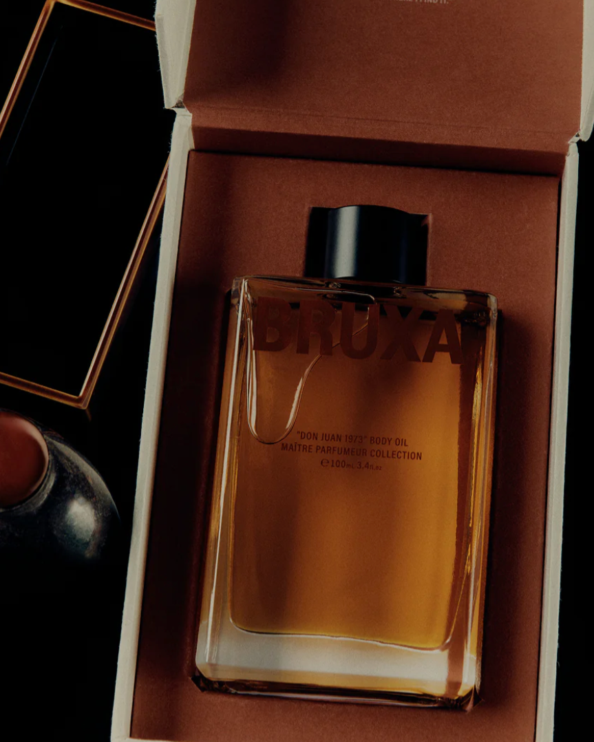 Brown perfume bottle in an open box with Bruxa branding.