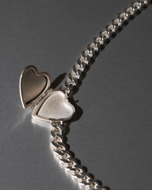 Silver chain with heart-shaped pendants on a gray background