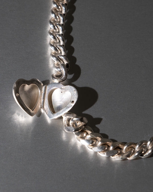 Silver chain with heart-shaped pendants on a gray background