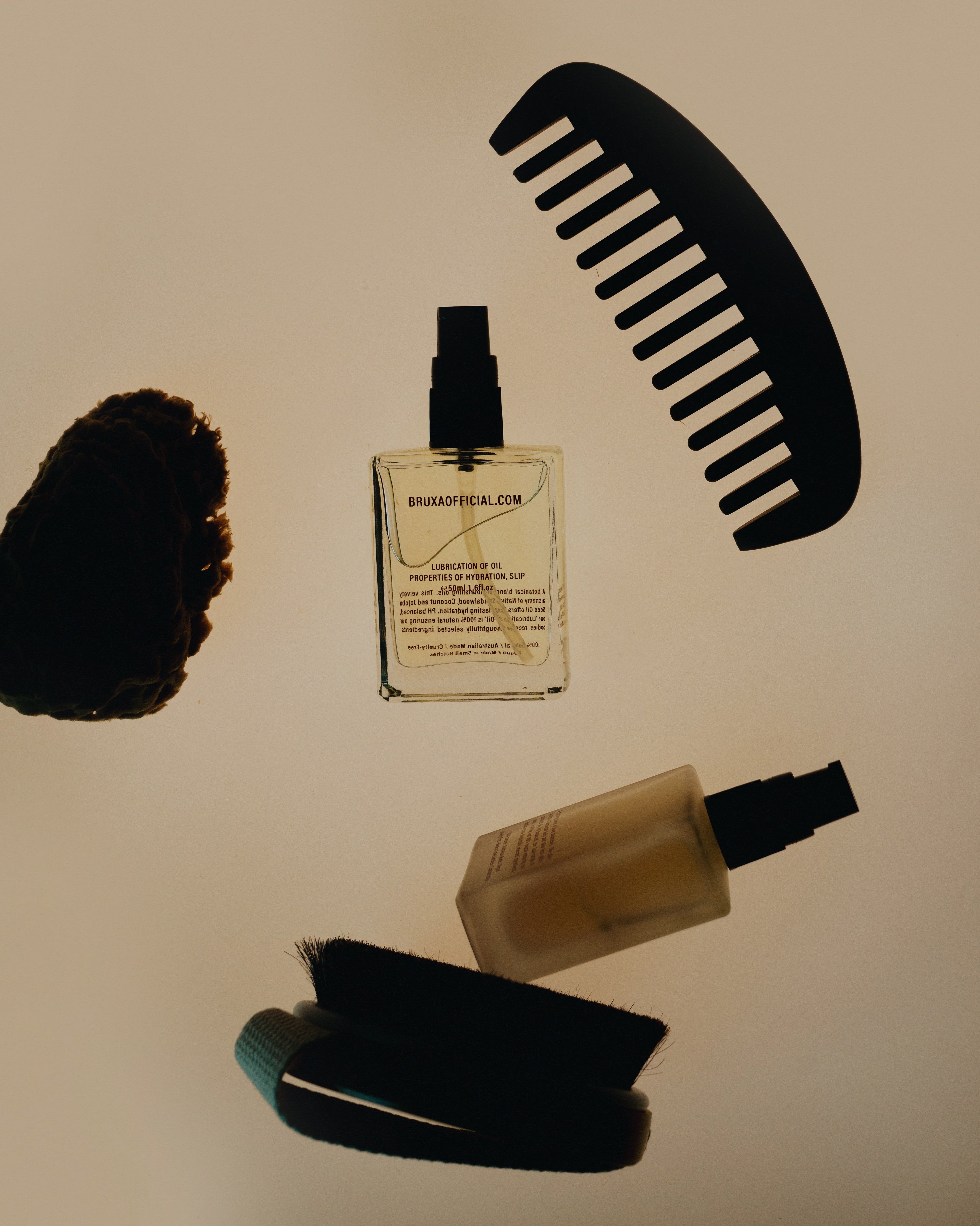Set of hair care products including a bottle, brush, and comb on a beige background