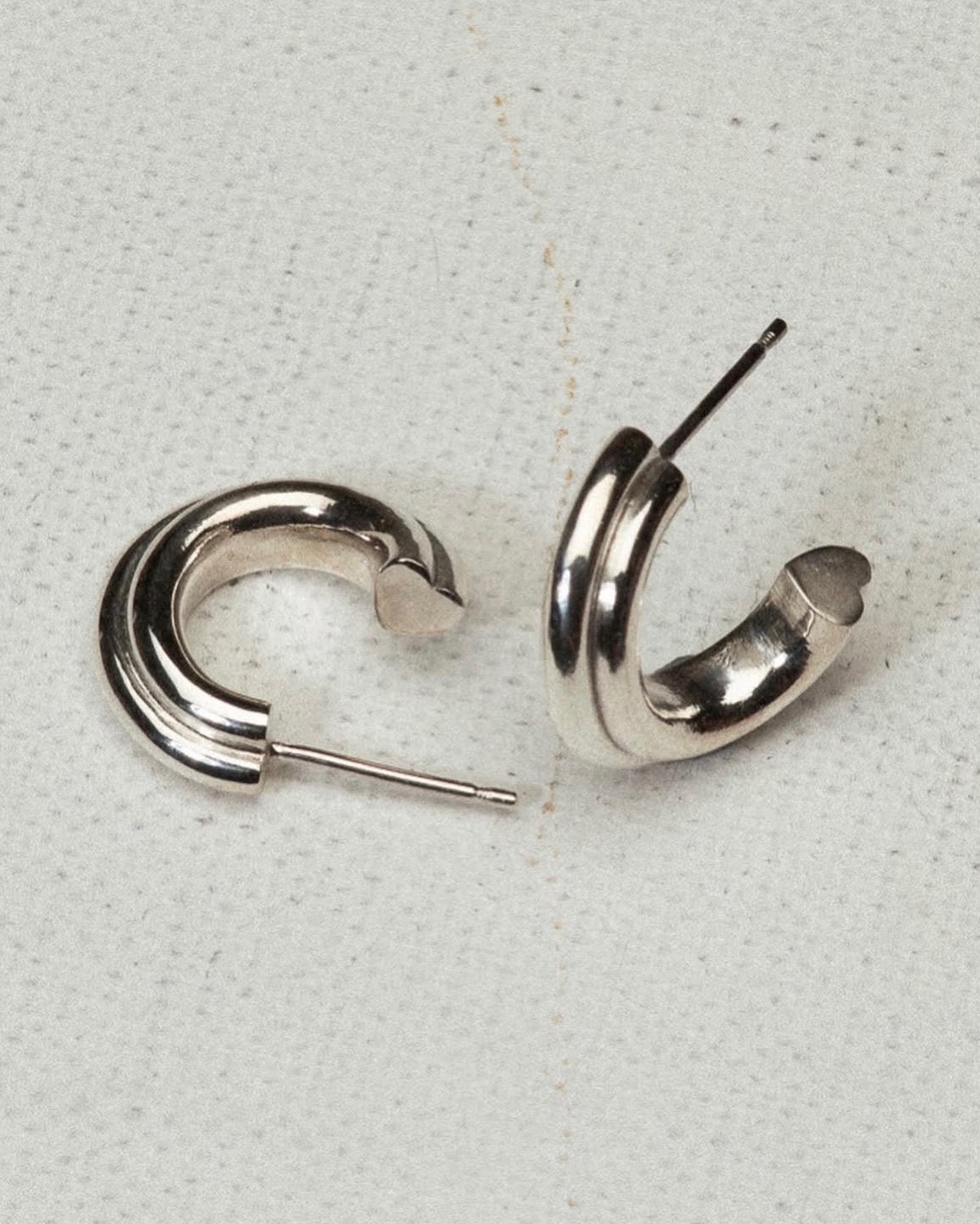 Pair of silver hoop earrings on a light gray background