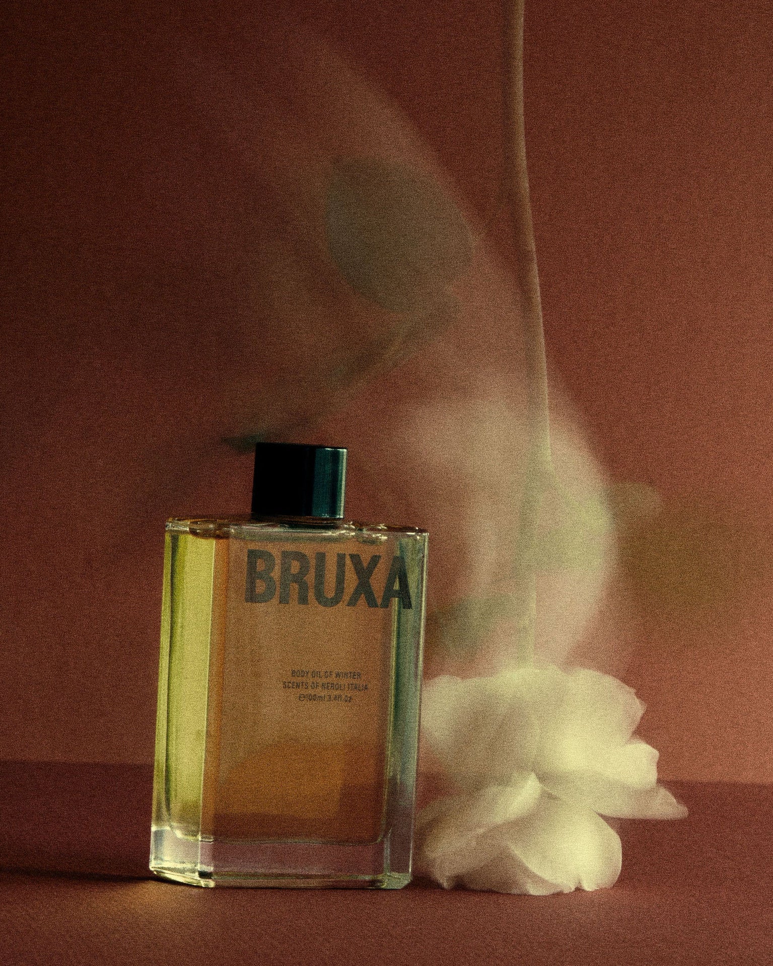 BRUXA perfume bottle with smoke effect on a dark background