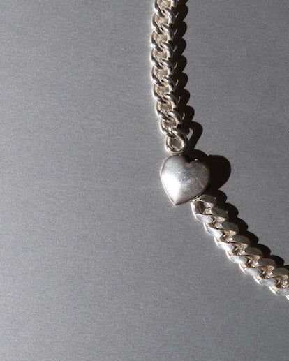 Silver necklace on a gray background