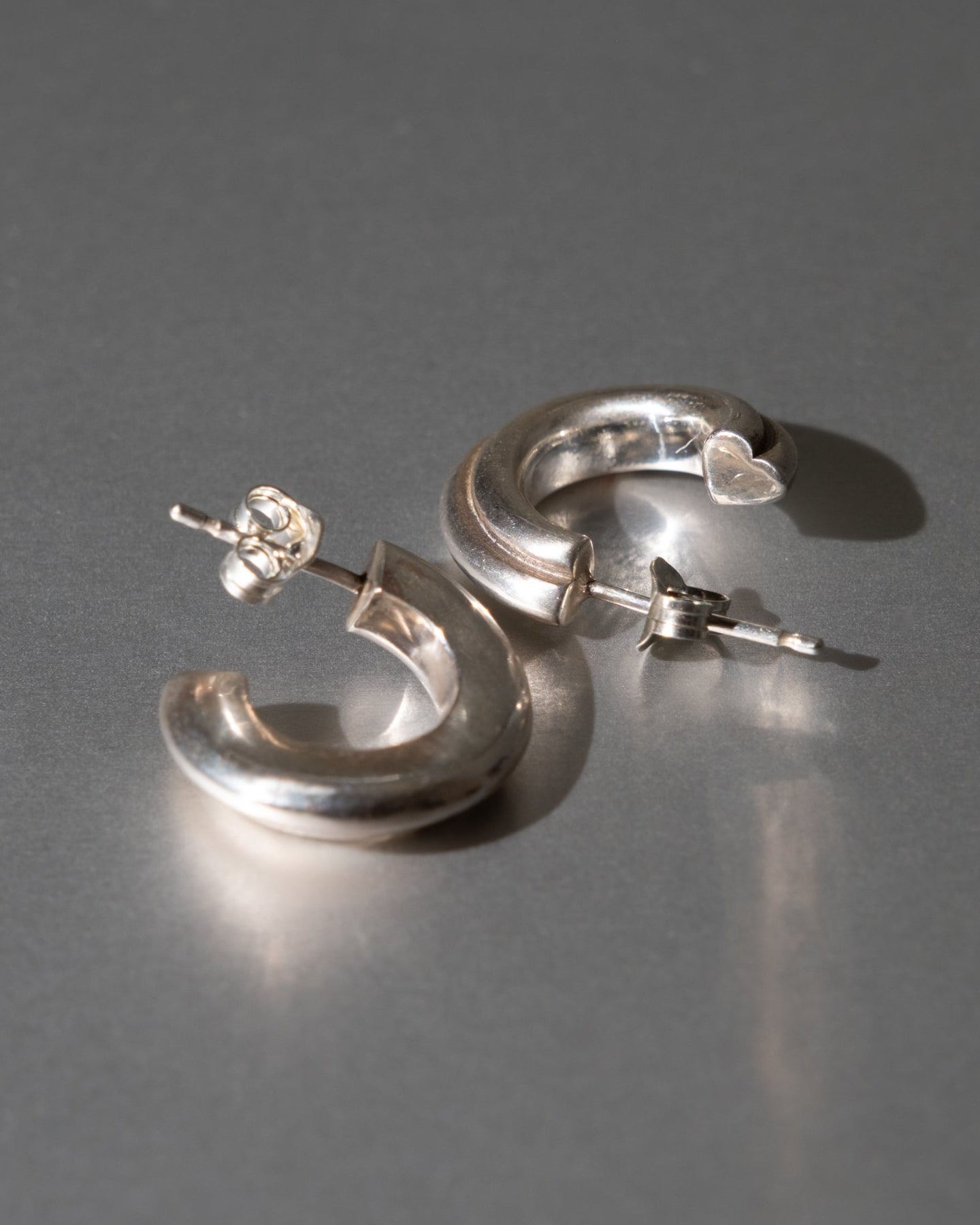 Silver hoop earrings on a gray background